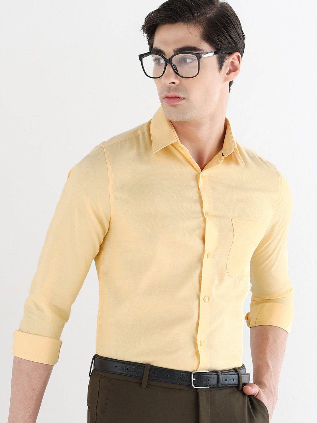 Man wearing a yellow shirt and brown pants against a white background