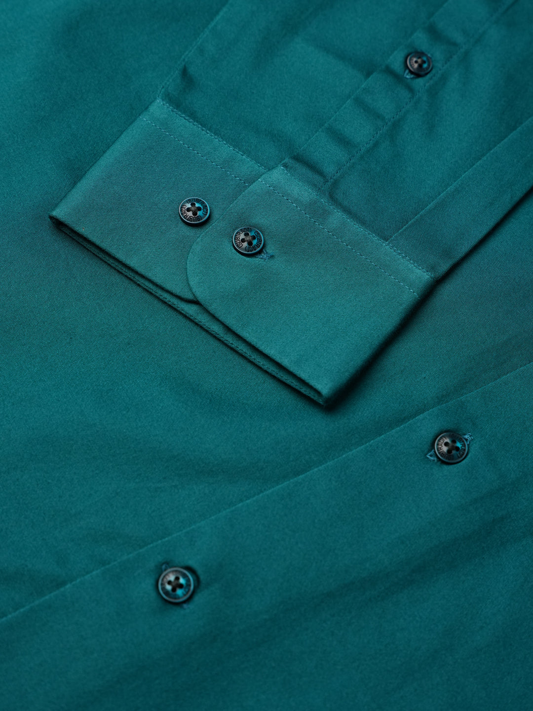 Close-up of a teal shirt with buttons and a pocket